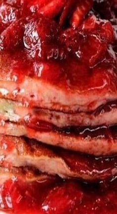 a stack of pancakes covered in strawberry jam