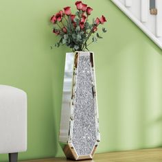 a vase filled with flowers sitting on top of a table next to a stair case