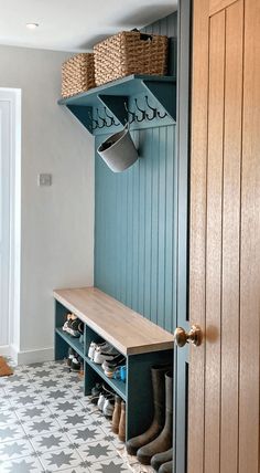 a wooden bench sitting under a coat rack filled with shoes