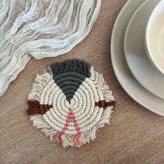 a white plate sitting on top of a wooden table next to a cup and saucer