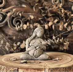 a small statue sitting on top of a wooden stump