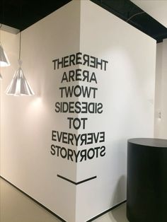 there are two large white walls with black lettering on the wall next to each other