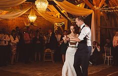 a bride and groom are dancing at their wedding reception in an old - fashioned barn