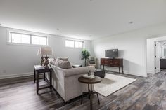 a living room filled with furniture and a flat screen tv on top of a wooden floor