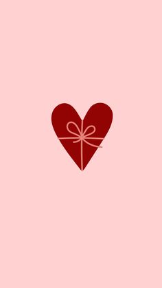 a red heart with a bow on it's side, against a pink background