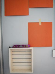 an orange piece of paper hanging on the wall next to a box with a pencil in it