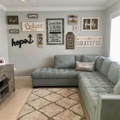 a living room with gray couches and pictures on the wall above it's coffee table