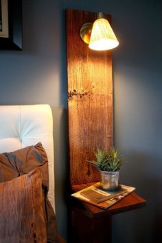 a lamp that is sitting on top of a table next to a book and potted plant