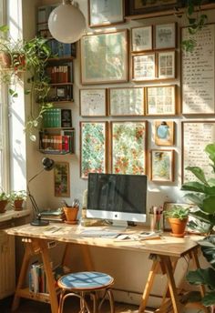 a home office with lots of plants and pictures on the wall behind the computer desk