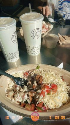 a plate of food and two cups on a table