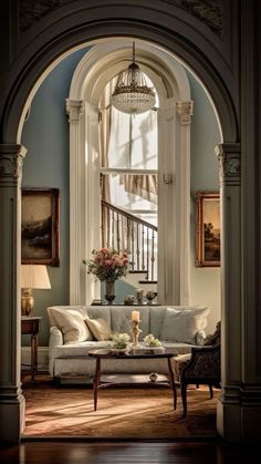 a living room filled with furniture and a chandelier hanging from the side of a window