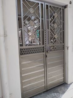 an iron gate is open on the side of a building