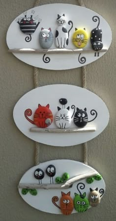 three white surfboards with cats on them hanging from the wall and two are holding magnets