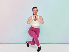 a woman in pink leggings and white top is smiling while posing for the camera