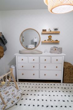 a baby's room with white furniture and accessories