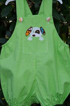 a green and white checkered overall with a dog applique on the front