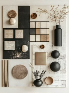 a table topped with lots of different items on top of a white wall next to a vase