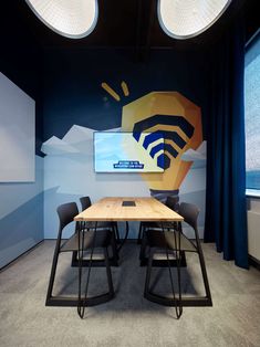 a conference room with blue curtains and black chairs, an art work on the wall