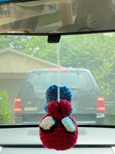 a stuffed animal hanging from the dashboard of a car