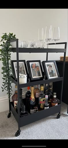 a bar cart with wine glasses and pictures on it