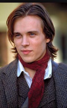 a young man wearing a red tie and jacket