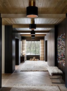 a living room with wood paneling and a large rug on the floor in front of a window