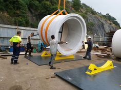 some men are working on an object that looks like a tube