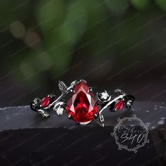 Gothic pear shaped red ruby engagement ring Art deco 14K black gold promise ring Unique nature inspired leaf ring Her handmade jewelry gift Engagement ring Center Stone: Lab ruby Cut: Pear shaped Size:6*8mm Side stone: Lab ruby + Moissanite Weight: 0.12ctw Width: 1.5mm Thickness: 1.2mm Wedding band Stone: Lab ruby + Moissanite Weight: 0.12ctw Width:1.2mm Thickness: 1.2mm Black gold: The underneath metal is in Silver/ 10K/14K/18K white gold, coated with black rhodium Or Metal: 925 sterling silver Nature Inspired Art, Gold Promise Ring, Garnet Engagement Ring, Engagement Ring Unique, Gold Promise Rings, Ruby Engagement Ring, Leaf Ring, Handmade Jewelry Gift, Art Deco Engagement Ring