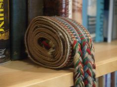 a roll of rope sitting on top of a book shelf