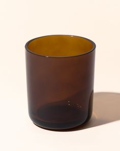 a brown glass cup sitting on top of a white table