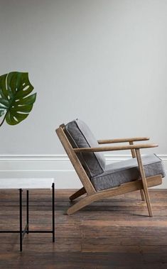 a wooden chair sitting next to a potted plant on top of a hard wood floor