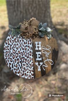 a wooden sign with the words happy new year hanging from it's side in front of a tree