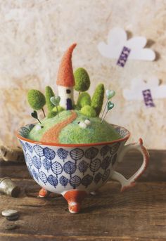 there is a small bowl that has some plants in it and a gnome's hat on top