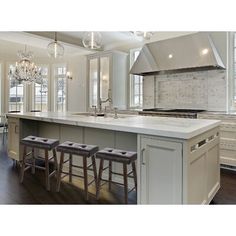 a large kitchen with an island and two stools