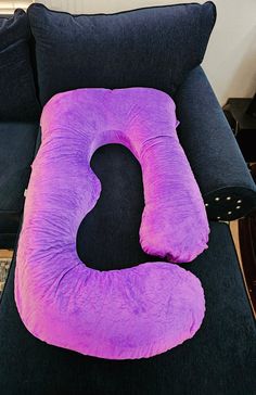 a purple pillow sitting on top of a black couch