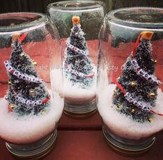 three snow globes with christmas trees in them