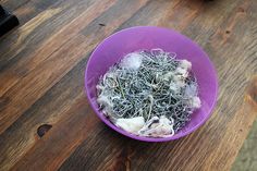 a purple bowl filled with seaweed on top of a wooden table