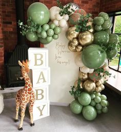 a baby shower with balloons and giraffe figurines