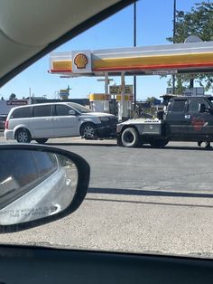 two trucks are parked in front of a gas station