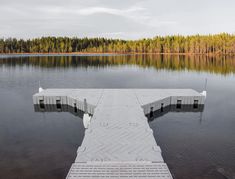 a dock sitting on top of a lake next to a forest