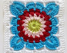 a crocheted square with a red, white and blue flower in the center