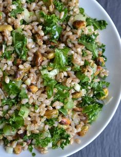 a white bowl filled with brown rice and veggies on top of a table