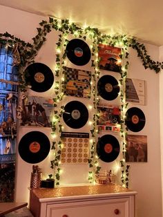 christmas lights are strung up on the wall behind record records and garlanded with greenery