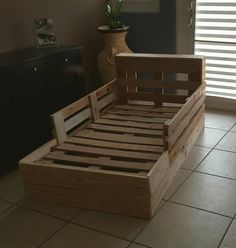 a bed frame made out of wooden pallets in a room with tile flooring