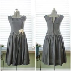 This is a simply darling number from the late 40s to early 50s. It is a gray, chambray cotton day dress with a drop-waist silhouette and the most dynamic, piped waistline. The square neckline is also piped in white and has wide shoulders straps. This dress has a soft, pleated a-line skirt which surely could be made more voluminous with a petticoat but is shown here without. At the hip is sewn on a rose millinery flower with strands of ribbon. The dress closes up the back with a metal zipper and hook and eye. Label: N/A Measurements: Best for a size xs. The dress can accommodate up to 25 inch, possibly 26 inch waist but definitely calls for a bust size smaller than 34B. Shoulders: 14.5 in. Underarm to underarm: 14.4 in. Waist: 13.5 in. Hips: open Length: 38 in. Condition: Excellent! No flaw Wide Shoulders, Tie Scarf, Dropwaist Dress, Day Dress, Drop Waist, The Square, Metal Zipper, Dress Clothes For Women, Petticoat