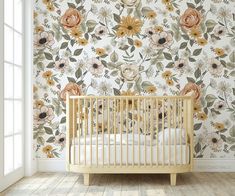 a baby's crib in front of a floral wallpaper