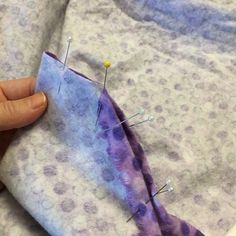 someone is stitching the fabric with pins and needles