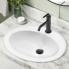 a bathroom sink with a black faucet and marble counter top