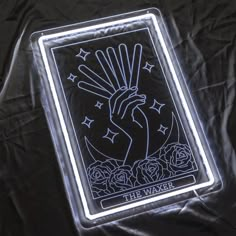 a lighted playing card with roses and stars on it is sitting on a black sheet