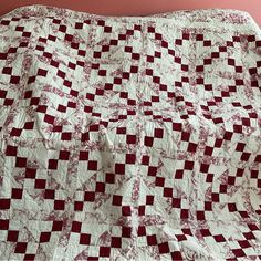 a red and white checkered quilt on a bed